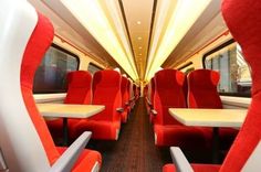 the inside of a train with red seats and thumbs up signs