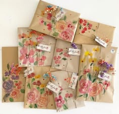 there are many small bags with flowers on them and tags attached to the bags together