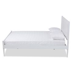 a bed with white sheets and pillows on it