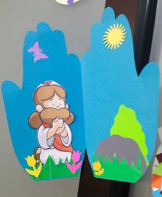 two hand puppets with images of jesus and mary on them, one is made out of paper