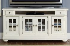 a white entertainment center with glass doors