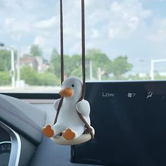 a toy duck hanging from the dashboard of a car