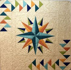 a quilted wall hanging with colorful stars on it