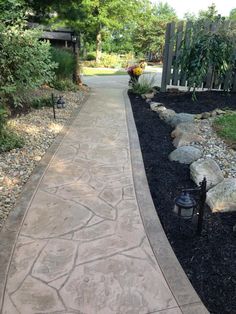 a walkway is lined with rocks and gravel