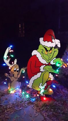 two christmas lights that look like characters from the grinch movie are in front of some trees