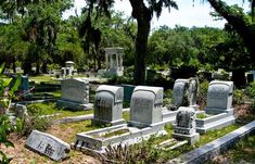 an old cemetery with many headstones and trees in the background