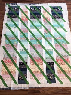 a quilted table runner with strips in the center and green tape on top of it