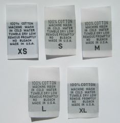 four pieces of white paper with black and white labels on them that say, 100 % cotton