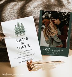 save the date cards are sitting on top of a bed next to a christmas tree