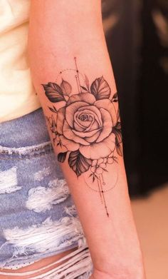 a woman's arm with a rose tattoo on the left side of her arm