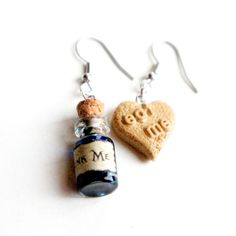 "These earrings feature Alice in Wonderland inspired \"Eat Me\" cookie and \"Drink Me\" potion charms. Both hangs on a silver tone , nickel free french hook. The \"Eat Me\" heart cookie charm measures 1.5 cm and the bottle pendant measures about 2 cm tall. The entire earrings length is 5 cm." Drink Me Potion, Silly Earrings, Alice Halloween, Crazy Earrings, Alice In Wonderland Gifts, Eat Me Drink Me, Alice In Wonderland Inspired, Heart Cookie, Alice In Wonderland Costume