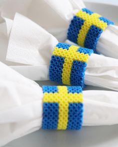 two blue and yellow lego blocks sitting on top of white napkins