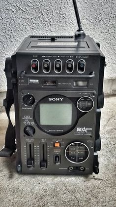 an old radio sitting on the ground next to a wall