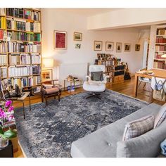 a living room filled with lots of furniture and bookshelves full of books on shelves