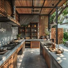 an outdoor kitchen with lots of counter space and wood accents on the walls, along with potted plants