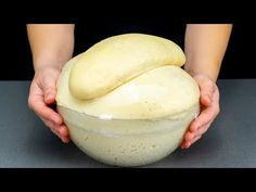 a person holding a bowl with some bread in it and their hands over the bowl