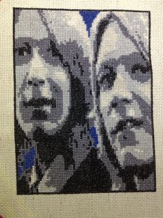 two people are shown in the middle of this cross - stitch pattern on a piece of fabric