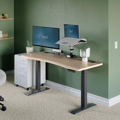 a desk with two monitors and a printer on it in an office space that has green walls