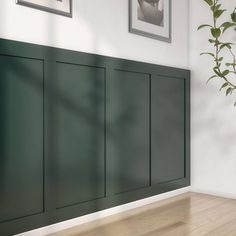 an empty room with green cabinet doors and pictures on the wall above it, along with hardwood flooring