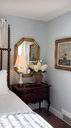 a bedroom with blue walls and white bedding