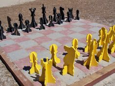 a giant chess set made out of yellow and black pieces