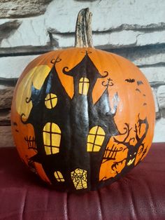 a painted pumpkin with a house on it