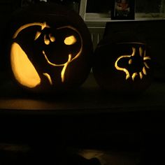 two carved pumpkins sitting on top of a table