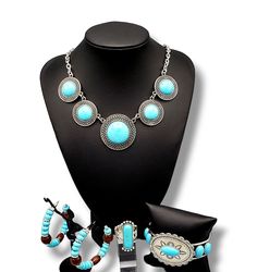 This trendy yet earthy Jewelry set comes with a necklace and complimentary earrings, upgraded earrings, a cuff bracelet, and a ring with a stretchy back.Necklace - "Circle The Wagons": Blue stones, pressed into round frames made of concentric rows of open circles, create a dramatically rustic statement as they link across the collar. Features an adjustable clasp closure. Includes one pair of matching earrings. Upgraded earrings - "​Definitely Down-To-Earth": An earthy collection of blue stone be Adjustable Costume Jewelry Sets With Round Shape, Turquoise Round Metal Jewelry, Blue Metal Jewelry, Southwestern Style Metal Jewelry For Gifts, Southwestern Style Metal Jewelry As Gift, Southwestern Style Metal Jewelry Gift, Nickel-free Turquoise Circle Jewelry, Southwestern Turquoise Metal Jewelry, Earthy Jewelry