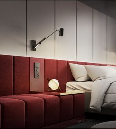 a red bed with white sheets and pillows next to a night stand in a bedroom