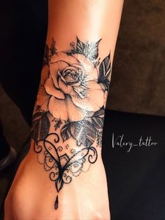 a woman's foot with a rose tattoo on it