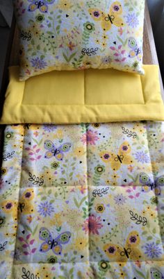 a bed with yellow sheets and pillows on top of it next to a pillow case