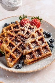 waffles with berries and powdered sugar on a plate