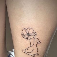 a tattoo on the leg of a woman with a duck and flower