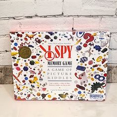 the spy memory game is on display in front of a white brick wall with an assortment of objects