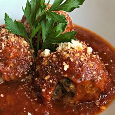 meatballs covered in sauce and garnished with parmesan cheese