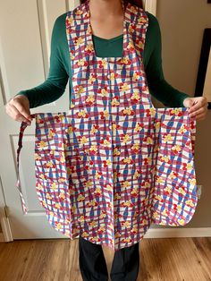 a woman is holding up an apron made out of fabric