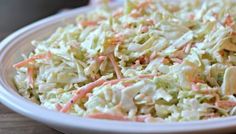 a white bowl filled with coleslaw on top of a wooden table