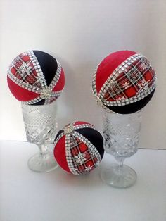 three glass goblets with red and black hats on them