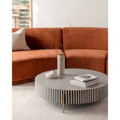 a round coffee table with a vase on top