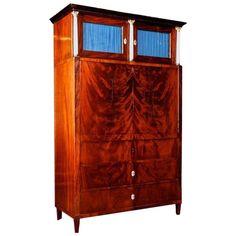 a wooden cabinet with two glass doors on the top and bottom shelves, inlaid with wood