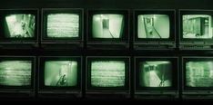 nine televisions are stacked up in rows and all have green lights on their screens