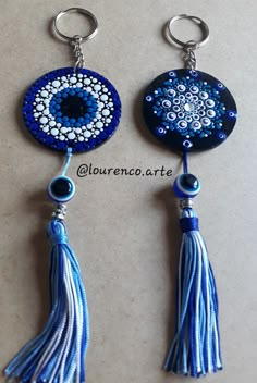 two blue and white beaded earrings with tassels on each earring, hanging from metal hooks