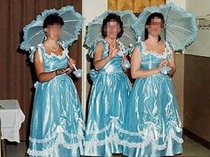 three women dressed in blue dresses and holding umbrellas