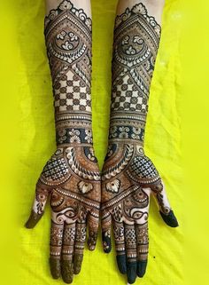 two hands with henna tattoos on them