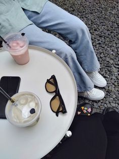 a person sitting at a table with their feet up on the table and some drinks