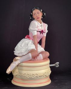 a woman sitting on top of a statue wearing white stockings and pink shoes with her legs crossed