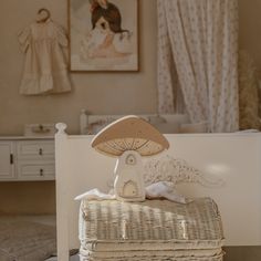 a wicker bed with a lamp on top of it in front of a painting