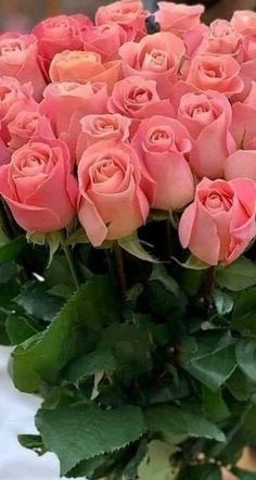 a bouquet of pink roses sitting on top of a table