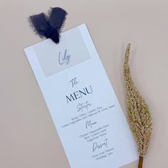 the menu card is next to a dried plant