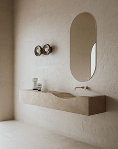 a bathroom with a sink, mirror and soap dispenser on the wall